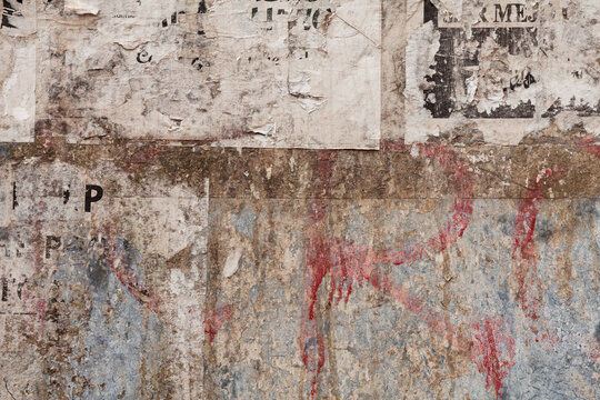grunge ripped poster on rusty iron sheet background - texture of torn advertisement on an old billboard panel