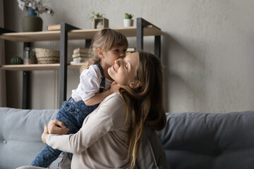 Peaceful positive young pregnant mother embracing sweet preschool daughter with love, tenderness, gratitude. Mom and little kid hug. Motherhood, childhood, family, mom and child affection