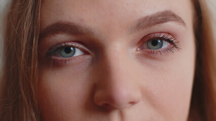 Close-up macro portrait of natural beauty young beautiful woman's eyes, smiling looking at camera. Gray eyes of woman face, girl female model. Lady opening blinking her eyes. Slow motion 4k footage