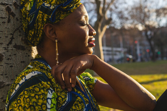 African woman resting near tree