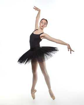 attractive ballerina stands on her fingertips. photo shoot in the studio on a white background
