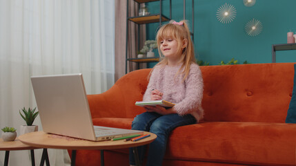 Online education at laptop of little child girl at home virtual class. Remote lesson studying of...