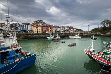 Fototapeta na wymiar Picturesque port area of Puerto de Vega town in Asturias, Spain with beautiful blue waters and fishing boats.