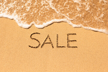 Fototapeta na wymiar Sale word written on sandy beach. Summer beach vacation sale concept. 