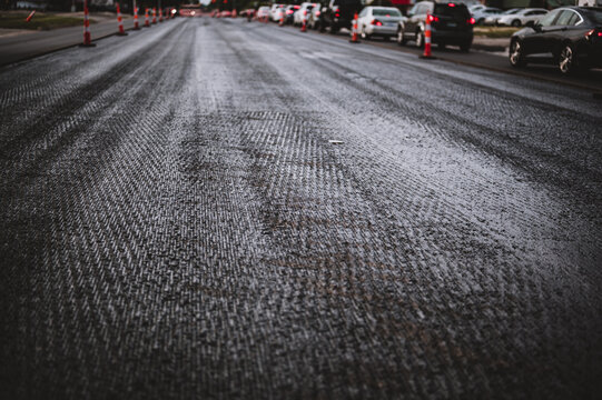 Low angle shot across a scarified street under construction with lanes on either side blocked off.