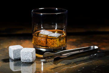 Whiskey stones on a black background, with reflection. Soapstone for chilling whiskey, studio shot.