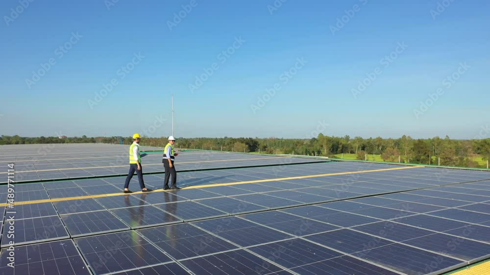 Wall mural professional engineer using drone and digital tablet maintaining solar cell panels together on build
