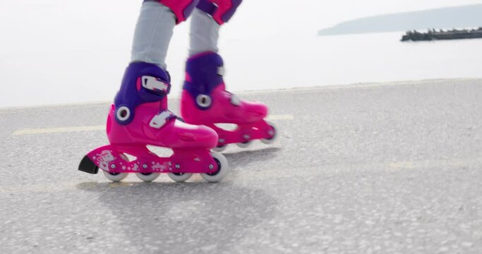 Little Girl Riding Roller Skates. Rollerblading Near Sea Coast, 4k Slow Motion Video