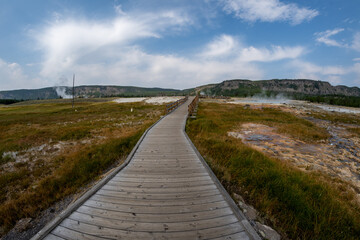 Fototapeta na wymiar Boardwalk trail leading to Biscuit Basin of Yellowstone National Park
