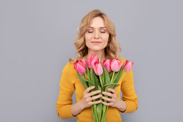 happy woman smell tulips. lady hold flowers for spring holiday. girl with bouquet