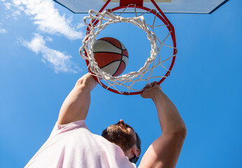 summer activity. man with basketball ball on court. professional basketball player © Olena