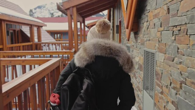 Female wearing winter clothes walking on touristic resort in Banff, View from behind