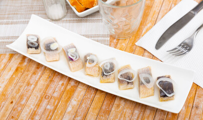 Appetizing herring fillet with onion on top, laid out on a plate. High quality image