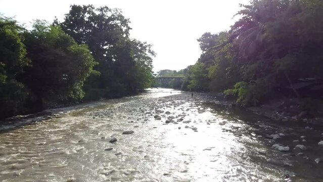 Hermoso río empedrado a lo largo del valle. Puente para cruzar
