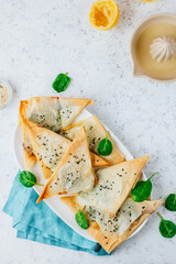 Homemade pies filo pastry with spinach and feta on the white background. Greek breakfast