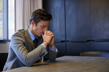 Obraz premium Its been a long day. Shot of a young businessman looking tired and stressed while sitting at his desk.