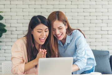 Happiness two women working together confident team meeting in office desk. Team business partners working with computer laptop startup company. Asian colleague friendship at work with smiling face.