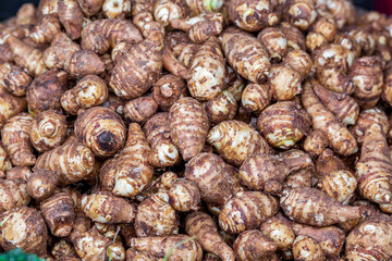 Fresh Taro (Kochur Mukhi) vegetable on the basket. Colocasia corms close-up view.