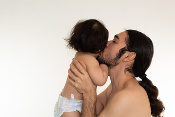 portrait of a hispanic father and son kissing on the cheek on a white background