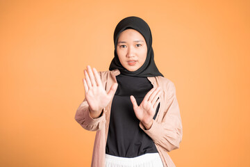Young asian muslim woman refusing with both palms gesture