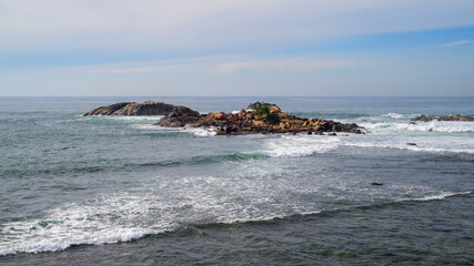 Small rocky island formation in the Indian ocean, Scenic seascape photograph high angle view.