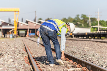 Engineer under inspection and checking construction process railway locomotive repair plant, Engineer man in waistcoats and hardhats and with documents in a railway depot