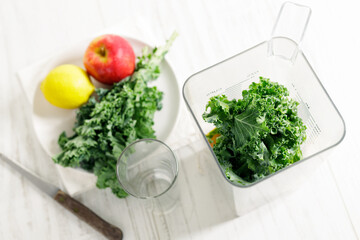 Blender filled with kale, apple and lemon.
