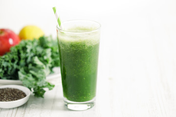 Green smoothies of kale, apple and lemon in a glass.