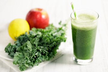 Green smoothies of kale, apple and lemon in a glass.