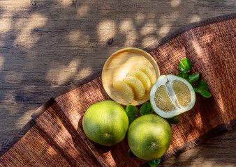 pamelo on a wooden plate with natural light on a wooden table in a garden