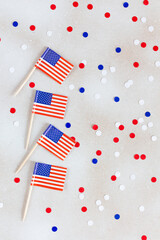 Obraz premium American flags flat lay on the white background with confetti. Happy Independence day USA.