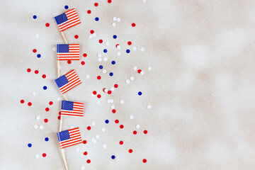 American flags flat lay on the white background with confetti. USA national day celebration.