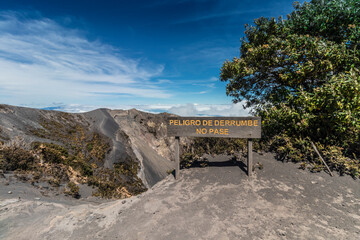 Wooden sign indicating danger of collapse and do not pass on the edge of a volcanic crater