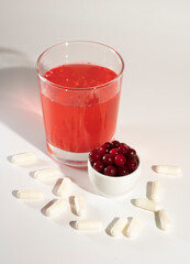 Glass of cranberry juice, cranberries, vitamins.