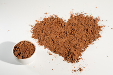 Poured heart-shaped cocoa powder, isolated on white background.