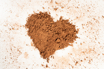 Poured heart-shaped cocoa powder, solated on white background.
