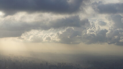 The beautiful city overlook view from the top of one skyscraper with the cloudy sky