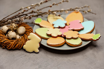 Spring holiday baking concept. Compositin of Easter cookies on grey concrete background. Colourful sugar cookies in shape of Easter eggs, carrots and flowers with decorative icing.