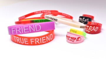 Close up shot of circular friendship wrist bands and friendship rings on white background