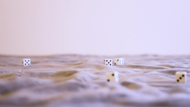 Rolling six white dice in extreme slow motion at eye level.