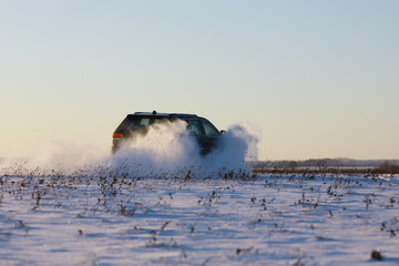 Car in the field in winter. Off-road winter snow drifts. Extreme sport, entertainment.