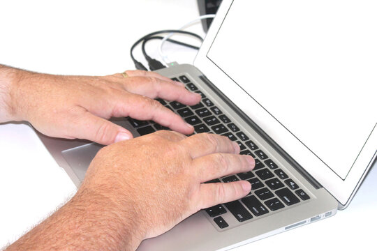 Male hands using a laptop computer with a black screen