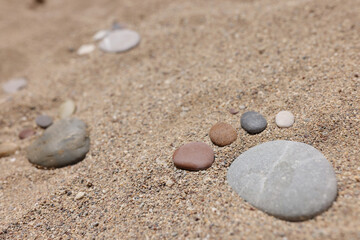 Fototapeta na wymiar Stone put in human foot shape on sand, hot summer day, coastline, sandy beach