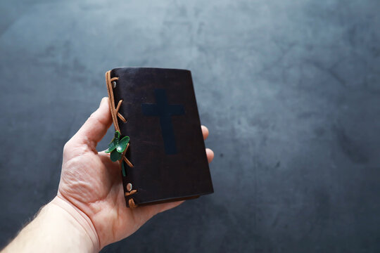 A leather-bound Bible on the table. Religious Christian Irish celebration. Four-leaf clover symbol of good luck.