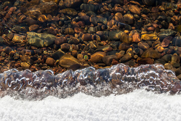 The edge of melting ice near the river bank in spring, natural background