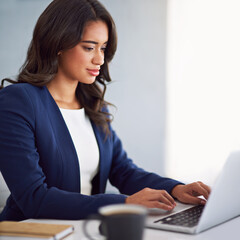 Shes always hard at work. Cropped shot of a young businesswoman working on her laptop.