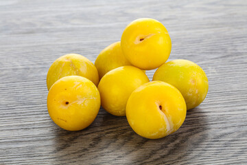 Ripe sweet yellow plum heap over background