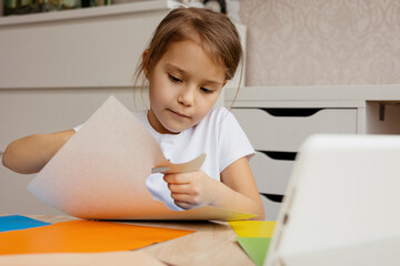 Naklejka premium A girl makes a DIY and watches an online lesson.