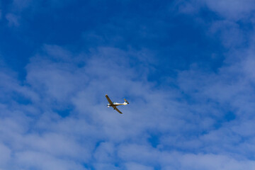 Fototapeta na wymiar Small ultra light plane fly against blue sky with clouds. Extreme sport, travel background with copy space