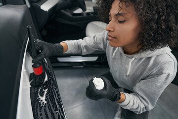 Professional detailer cleaning interior of customer vehicle